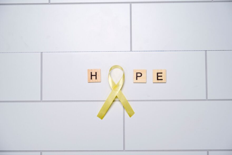 yellow ribbon symbolizing hope on white tiles
